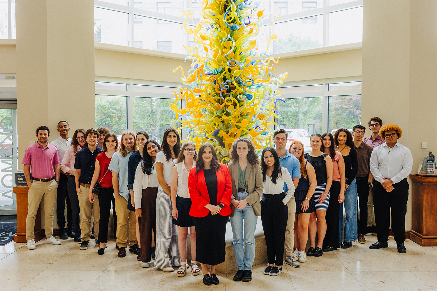 A photo of the 2024 Inasmuch Foundation Community Fellowship class in front of the Chihuly glass sculpture at the Oklahoma City Museum of Art.